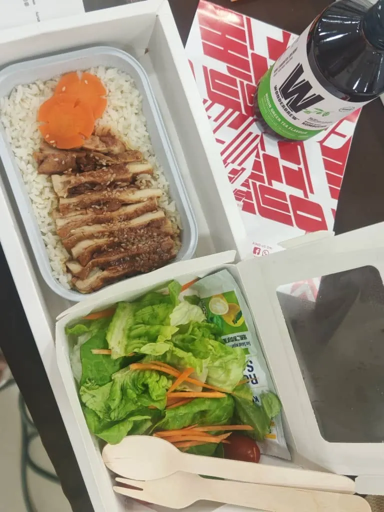 A TEDxPetalingStreet 2024 lunch set in paper food boxes with a wooden fork and spoon