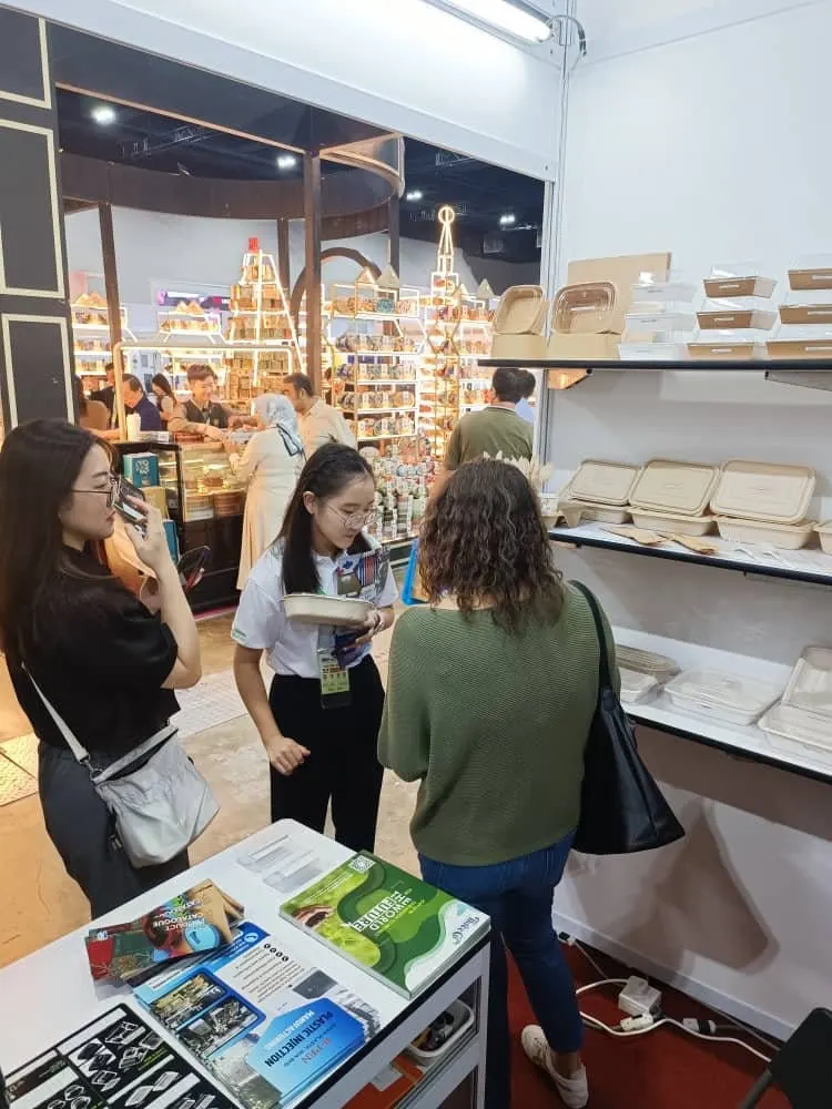 A B Eco Packaging team member showing a bagasse container to visitors at the MIMF 2025 booth