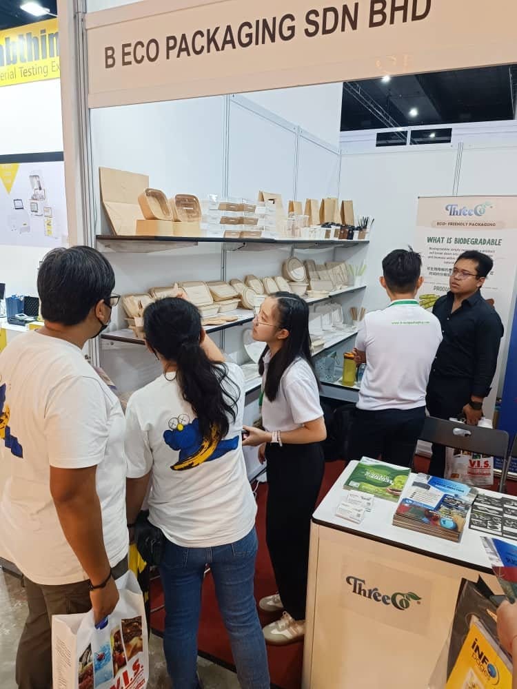 Pengunjung berbual dengan kakitangan B Eco Packaging di hadapan rak pameran pembungkusan eko